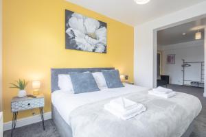 a bedroom with a large white bed with blue pillows at Cambridge Home Suite 5 in Cambridge