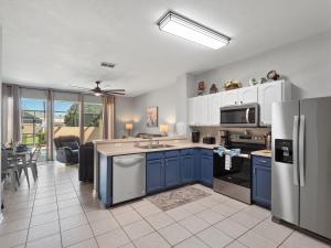 a kitchen with blue cabinets and a refrigerator at Mickey's Splash Pad, 2 Miles To Disney in Orlando