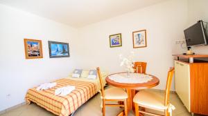a room with a bed and a table and a tv at Apartments Mija in Bol