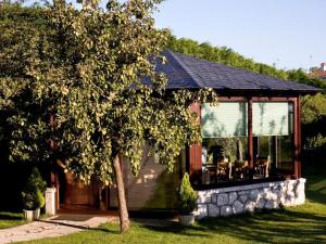 une maison avec une grande porte en verre et un arbre dans l'établissement Hostería los Sauces, à Maoño