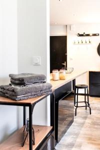 eine Küche mit einem Tisch und einer Theke mit Handtüchern in der Unterkunft LE PTIT LOCMARIA - Calme - Wifi - Proche Centre ville in Quimper