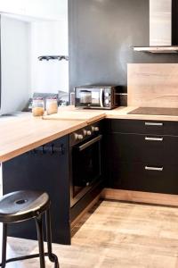 uma cozinha com um balcão de madeira e um fogão forno superior em LE PTIT LOCMARIA - Calme - Wifi - Proche Centre ville em Quimper