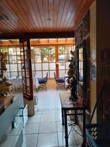 a living room with a table and chairs and windows at Hotel Boutique 3 Poniente in Viña del Mar