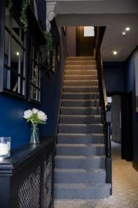 una escalera en un edificio con un jarrón de flores en Debenham Lodge Margate en Kent