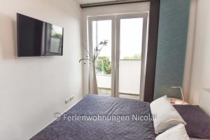 een slaapkamer met een bed, een tv en een raam bij Deichresidenz Stein in Stein