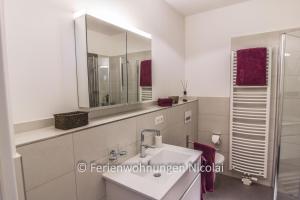 een badkamer met een wastafel en een spiegel bij Deichresidenz Stein in Stein +13 foto's