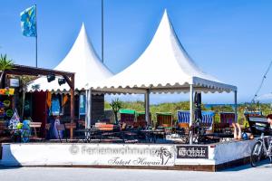 een groep stoelen en tafels onder een witte tent bij Deichresidenz Stein in Stein