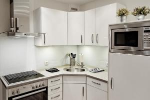 a white kitchen with a sink and a microwave at Meerblick Kalifornien in Kalifornien