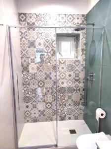 een douche met een glazen deur in de badkamer bij Casa Vacanze Onda Azzurra (Deluxe) in Peschici