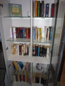 a book shelf filled with lots of books at Ferienzimmer Alte Kämpe in Heede