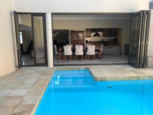 a house with a swimming pool and a bedroom at Swanepoel Guesthouse & Suites in Jeffreys Bay
