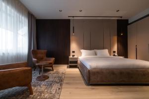 a hotel room with a bed and a chair at Emery Hotel in Pristina