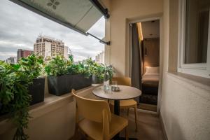 a small table and chairs on a balcony with plants at Emery Hotel in Pristina