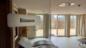 una camera con una parete in vetro, un divano e una sedia di Ferienwohnung Sonnensegler Wohnung 220 a Baabe