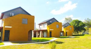 a row of houses on a grassy field at Cabañas Madre Sierra in Santa Rosa de Calamuchita