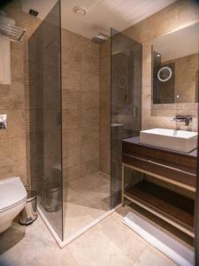 y baño con ducha, lavabo y aseo. en Emery Hotel en Pristina