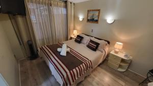 een slaapkamer met een bed met een wit kruis erop bij Hotel Boutique 3 Poniente in Viña del Mar