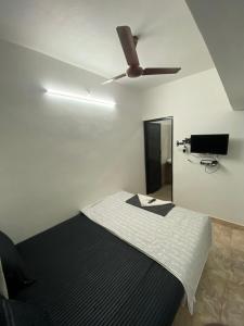 マハーバリプラムにあるThe Sea Shelter Home Stayのベッドルーム1室(ベッド1台、シーリングファン付)