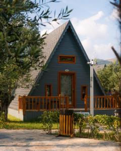 ein blaues Haus mit einer Veranda und einer Terrasse in der Unterkunft Verde Blu Bungalow in Edremit