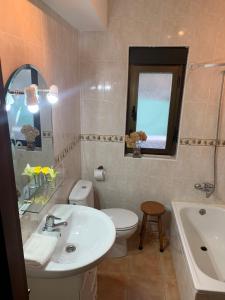 y baño con lavabo, aseo y espejo. en Casa Rural Fuentecillas en Becedas