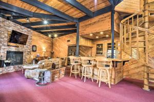 Habitación grande con paredes de madera y bar con taburetes. en Cozy Grand Woodland Cabin with Mountain Views, en Pine Mountain Club