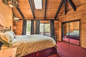 1 dormitorio con 1 cama en una habitación con paredes de madera en Cozy Grand Woodland Cabin with Mountain Views, en Pine Mountain Club