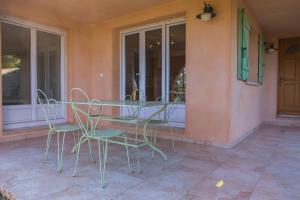 une table et des chaises assises sur une terrasse couverte dans l'établissement Appartement T2 rez de villa, à Saint-Florent