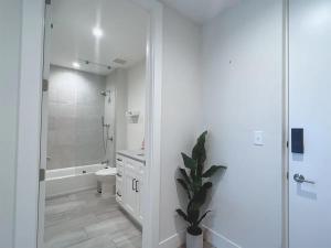 a white bathroom with a toilet and a shower at Lux property great for 1 to 8 Guests-family trip ,5Beds 2Rooms Staycation with Gym and EV, proximity to Downtown and Beaches in West Palm Beach