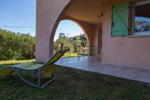 einen Stuhl außerhalb eines Hauses mit Terrasse in der Unterkunft Appartement T2 rez de villa in Saint-Florent