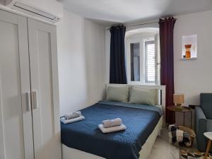 Apartment Augustini في كريس: غرفة نوم صغيرة مع منشفتين على سرير