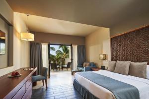 a hotel room with a bed and a balcony at Fanar Hotel & Residences in Salalah