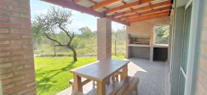 un patio con una mesa de madera y una ventana en Cabañas Madre Sierra en Santa Rosa de Calamuchita