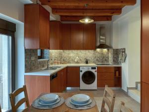 a kitchen with a table and a washing machine at La Casa Di Manou in Plataniás