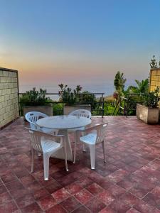 un patio con tavolo, sedie e vista sull'oceano di Villa Master a Cefalù