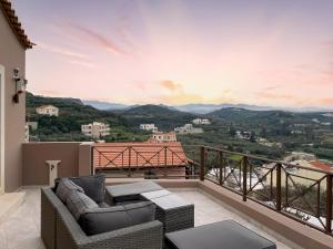 a balcony with couches and a view of the mountains at La Casa Di Manou in Plataniás