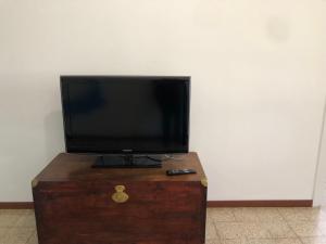 a television on top of a wooden chest with a remote control at IL SICOMORO in Sansepolcro