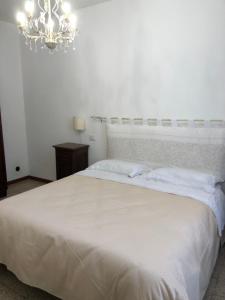 a bedroom with a large white bed with a chandelier at IL SICOMORO in Sansepolcro