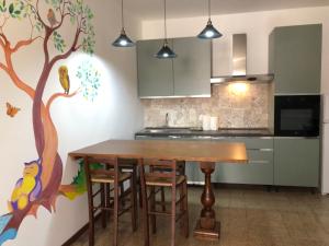 a kitchen with a wooden table and a tree painted on the wall at IL SICOMORO in Sansepolcro