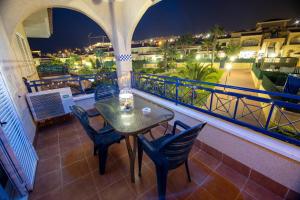 una mesa y sillas en un balcón con vistas en Disfruta de la playa y piscina, acogedora casa, en Santa Pola