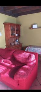 a red couch in a room with a table at La casina de castiello in Arriondas