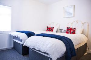 a bedroom with two beds with blue and white blankets at The Great William St. Cottage in Stratford-upon-Avon