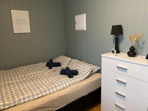 um quarto com uma cama com chapéus e uma cómoda em Apartment Tromsdalen. Tromsø em Tromsø