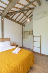 Un dormitorio con una cama amarilla con un animal de peluche. en Singgah di Ubud 1 en Ubud