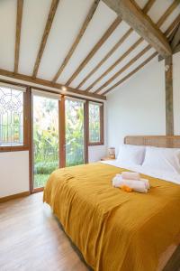 sypialnia z dużym łóżkiem z żółtą narzutą w obiekcie Singgah di Ubud 1 w mieście Ubud