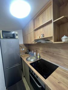 a small kitchen with a sink and a refrigerator at Apartman Eden in Brčko