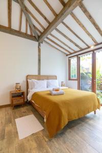 een slaapkamer met een groot bed en een gele deken bij Singgah di Ubud 1 in Ubud