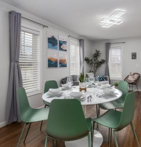 a dining room with a white table and green chairs at Starved Rock & Ottawa Retreat Amazing Getaway Home in Ottawa