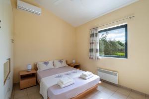 a bedroom with a bed and a window at Green House - Εξοχική κατοικία με μεγάλο κήπο in Nerotriviá