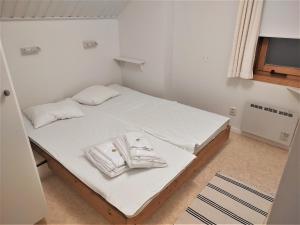 um pequeno quarto com uma cama com lençóis brancos e toalhas em Holiday Club Åre Tegefjäll em Åre