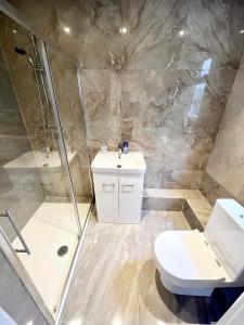 a bathroom with a shower and a toilet and a sink at 3 Cosy Homes Walking Distance to Mall with Parking Available to Book Separately 3 Bed House Or 1 Bed Apartment Or Studio in Golders Green